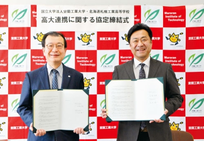写真：協定書を手に笑顔を見せる空閑学長（左）と太田校長