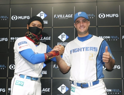 写真：入団記者会見で新庄監督（左）とポーズをとる日本ハムのマルティネス＝エスコンフィールド