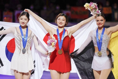 写真：女子で２連覇を果たし、日の丸を広げる坂本花織（中央）。左は２位の李海仁＝さいたまスーパーアリーナ