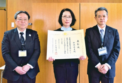 写真：表彰状を受け取る柳瀬教諭（中央）