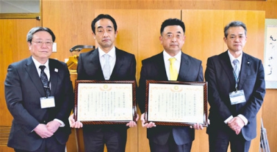 写真：表彰状を受け取った柴山校長（左から２人目）と吉井教諭（右から２人目）