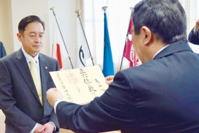 写真：正六位の位記を受ける亀谷隆雄さんの長男・和人さん（左）