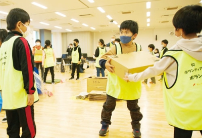 写真：避難所運営を想定して手渡し運搬を体験した子どもたち