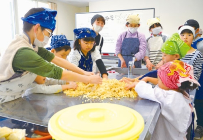 写真：こうじと大豆を混ぜる子どもたち