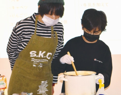 写真：講師の檜山さん（左）と一緒にスープを作る男の子