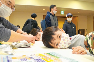 写真：机に耳を当てて音の振動を確かめる子ども