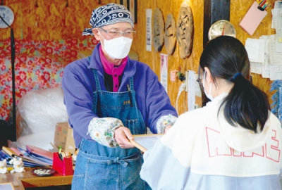写真：修了証を手渡し、子どもたちを激励した津村さん