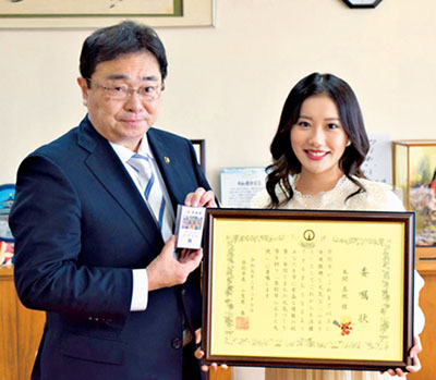 写真：ふるさと大使に就任した本間さん（右）