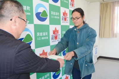 写真：渋川教育長善意を手渡す今野さん（右）