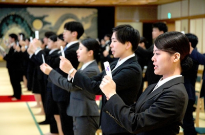 写真：社是や行動指針などを読み上げる新入社員ら