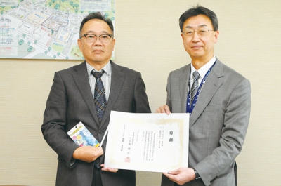 写真：目録を手にする種田教育長（右）と島田会長
