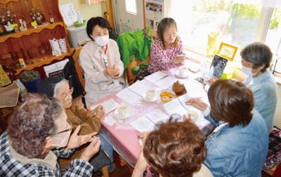 写真：ヨガアシスタントの清水さん（左から３人目）から指ヨガを教わるサロン参加者