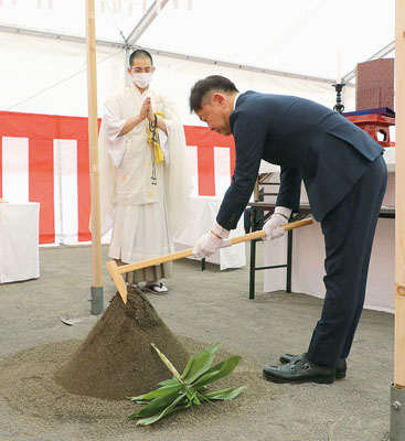 写真：くわ入れして、病院新築工事の安全を祈願する三井理事長