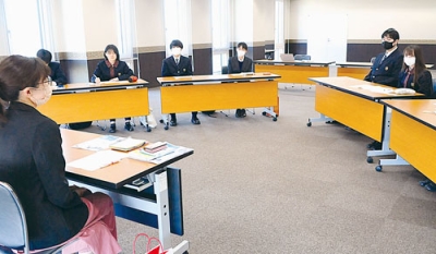 写真：室蘭信用金庫を訪れ、職員と交流、取材をする生徒たち