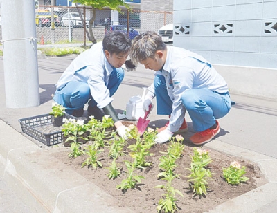 写真：植樹升に花苗を植える東海建設社員
