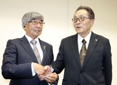写真：千島歯舞諸島居住者連盟の総会後、握手する前理事長の脇紀美夫氏（左）と新理事長の松本侑三氏＝２９日午後、札幌市