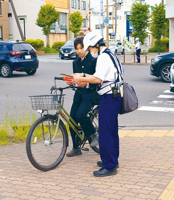 写真：自転車利用者に事故防止を呼びかける室蘭署員