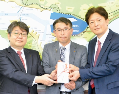 写真：岩見部長（右）と黒龍後援会長（左）に寄付金を手渡す山田専務