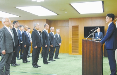 写真：副知事や部長らに「新しい体制で力を合わせていこう」と訓示する鈴木知事（右）