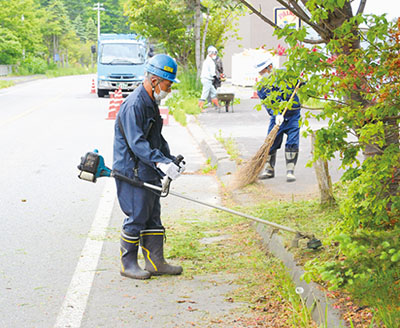 写真：草刈りに汗を流す参加者