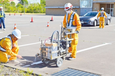 写真：市民プール駐車場で社会貢献活動に励む日本マーキングの社員