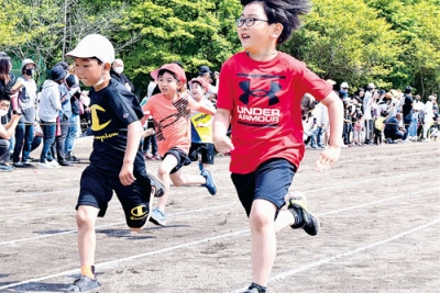 写真：仲間や父母らの声援を受けて全力疾走する児童＝青葉小