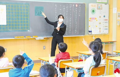 写真：みなと小の児童に漢字の書き順を指導する教育実習生の澤口さん