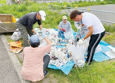 写真：集めたごみを仕分けする住民たち
