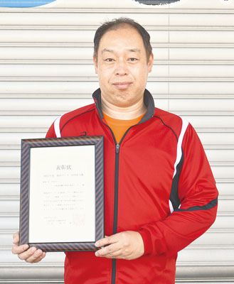 写真：表彰状を手にする江良施設長