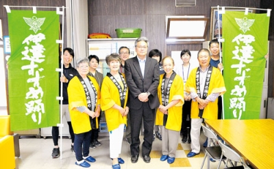 写真：寄贈したのぼりを囲む雅会のメンバーと伊達小の先生たち