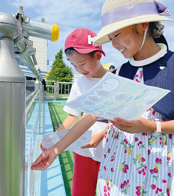 写真：水族館の中に隠されているシールを見つけ、集める子どもたち
