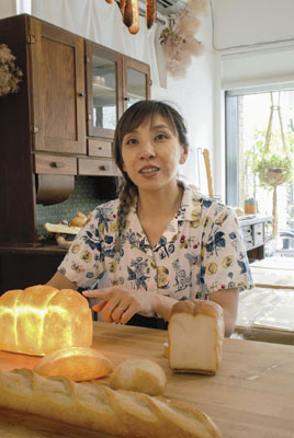 写真：パンに光源を仕込んだ「パンプシェード」について説明する「パンセム」代表の森田優希子さん＝７月、神戸市