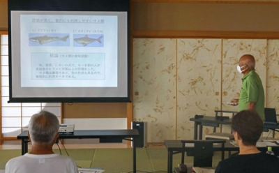 写真：勉強会で、サメの食味実験結果を紹介する仲谷一宏北海道大名誉教授（奥）＝８月２２日、函館市