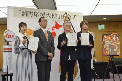 写真：消防応援大使の任命式で写真に納まる（左から）声優の佐倉綾音さん、松本総務相、アニメ「め組の大吾　救国のオレンジ」原作者の曽田正人さん、声優の八代拓さん＝５日午前、総務省