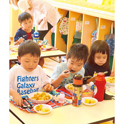 写真：おいしそうにカレーを食べる清泉幼稚園の園児たち