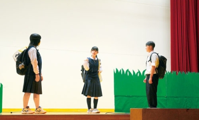 写真：ステージで元気よく演劇や合唱を披露する翔陽中の生徒