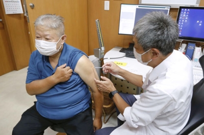 写真：クリニックで新型コロナの改良型ワクチンを接種する男性＝２０日午前、東京都港区