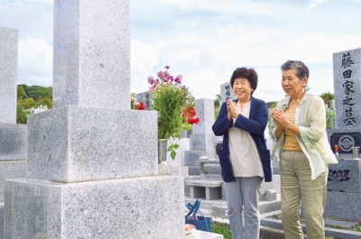 写真：彼岸に入り手を合わせる松原さん（右）と坂口さん＝２０日、室蘭市神代町