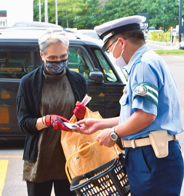 写真：買い物客に飲酒運転撲滅の啓発グッズを手渡す参加者
