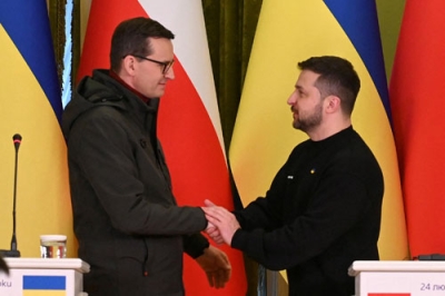 写真：２月、ウクライナ・キーウでの共同記者会見で握手するゼレンスキー大統領（右）とポーランドのモラウィエツキ首相（ロイター＝共同）
