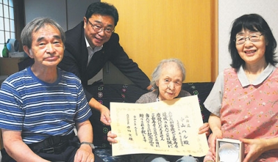 写真：内閣総理大臣のお祝い状と銀杯を受け取った中山さん（右から２人目）
