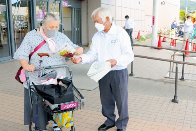 写真：啓発品を手渡す協議会メンバー
