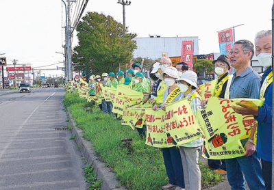 写真：行き交うドライバーに交通安全を呼びかけた参加者＝イオン登別店前
