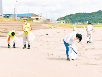 写真：イタンキ浜で清掃活動に励む幌清の社員ら