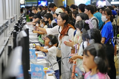 写真：「東京ゲームショウ２０２３」の一般公開が始まり、４年ぶりに復活した「ファミリーゲームパーク」で楽しむ多くの親子＝２３日午前、千葉市の幕張メッセ