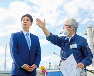 写真：プラント設備の説明を受ける鈴木知事（左）