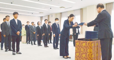 写真：空閑学長（右）から修了証を受け取る学生