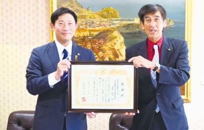 写真：青山市長（左）から感謝状を受け取る栗林社長