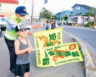 写真：旗の波で交通安全を呼びかける参加者