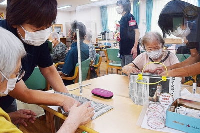 写真：新聞紙のエコバック作りを行う利用者
